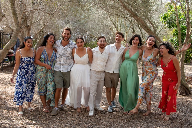 שמונה חברים מחבקים זה את זה וצוחקים למצלמה