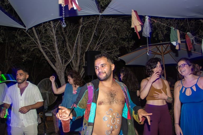 אורחים רוקדים בערב מתחת לתאורה צבעונית